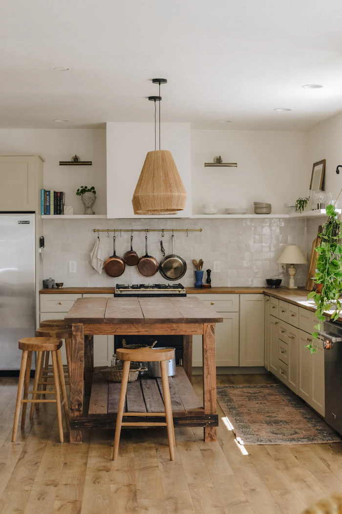 After: finished kitchen with wood island, open shelves and copper pots