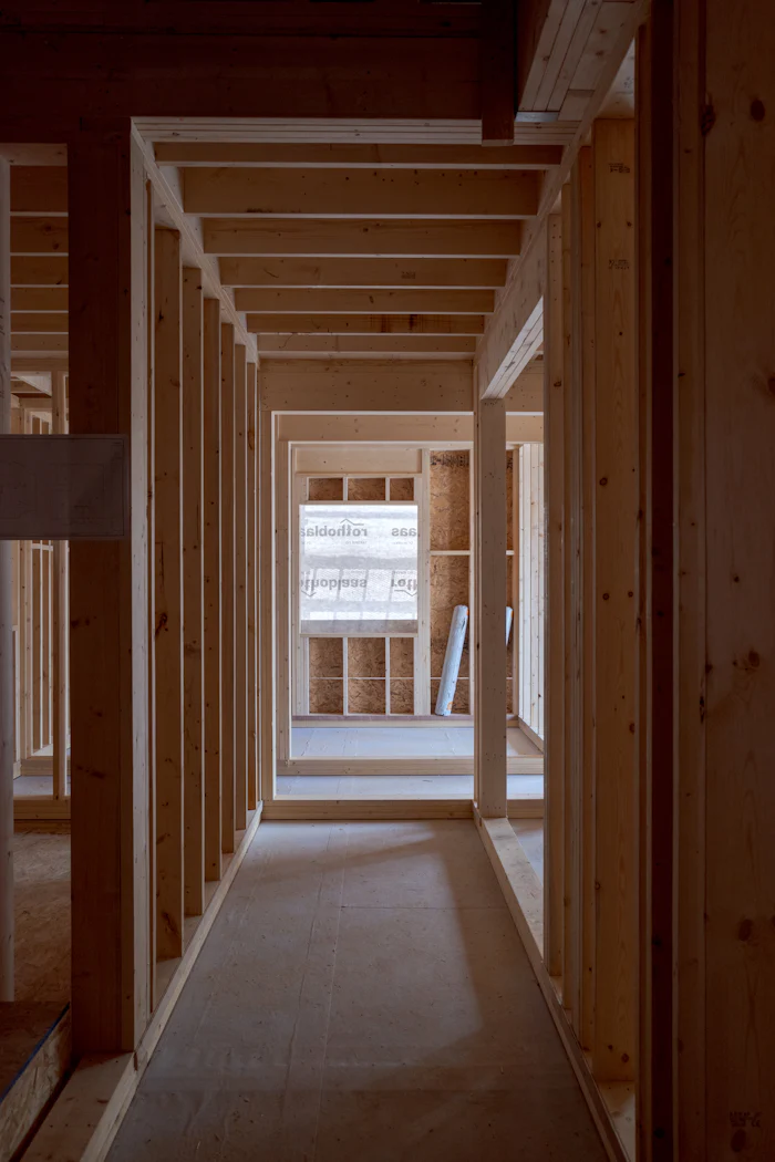 Hallway of fresh wood stud framing leading to a window